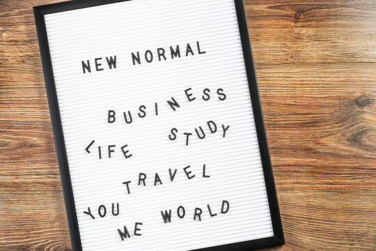 NEW NORMAL text on white letter board background. Adapting to new life or business post-lockdown change after COVID pandemic. Business with social distancing personal hygiene, world travel and study