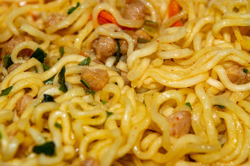 Cooked instant noodles with spices, dried vegetables and freeze-dried meat. Close up.