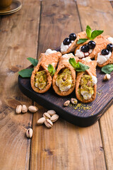 Cannoli Sicily. Traditional Italian sweet with ricotta and various fillings. Food on a wooden cutting board