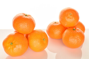 Bright yellow juicy, fresh, organic tangerines, close-up, on a white background.