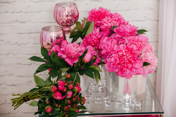 composition of peonies in silver boxes standing on a glass table