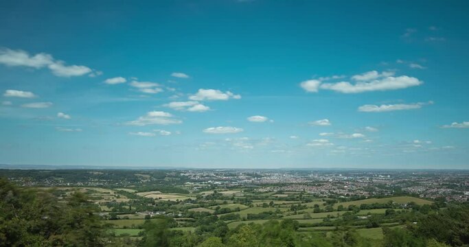Time lapse of clouds over distant town in England countryside
