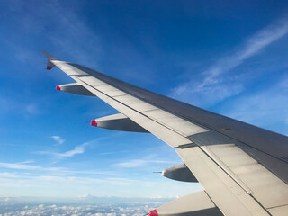 Fototapeta premium Wing of commercial aircraft against a blue sky. No people. Space for copy.