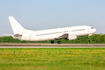 Fototapeta na wymiar Take-off from the runway of a white passenger aircraft on a clear summer day