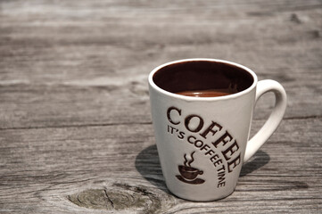 Beige cup of coffee on a wooden background
