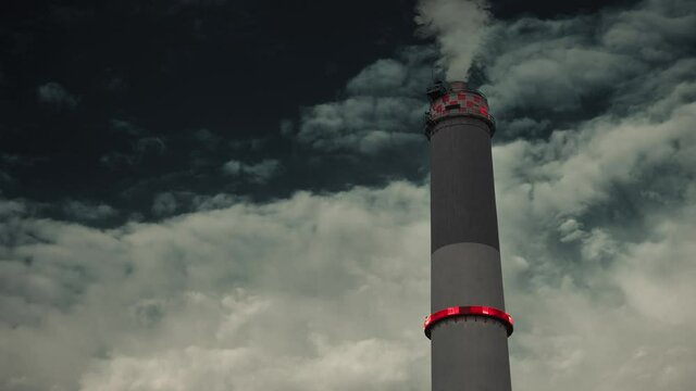 Cinemagraph of smoke emitted from the chimney of the Reading power plant on a dark sky. It located in Tel Aviv, Israel. Concept of industry, pollution, electricity, or environmental protection. Loop.