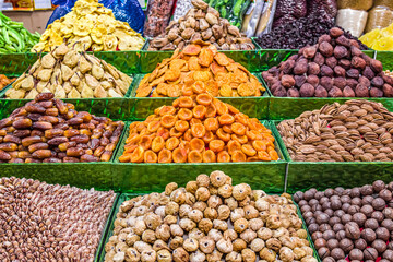 Dried fruits and nuts for sale on a market counter.