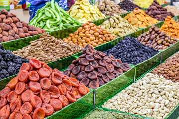 Dried fruits and nuts for sale on a market counter.