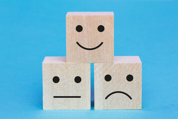 Wooden square blocks with facial expressions negative, neutral and positive. Customer service evaluation  and satisfaction survey concept . Feedback icons for client