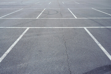 Dark asphalt road with marking lines. Tarmac texture. White disabled sign on a empty parking lot. Black tarmac texture with road marking 