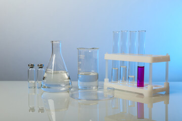 blue background with lab glassware and chemical flasks in laboratory with copy space. 