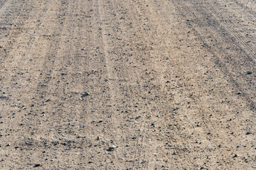 Empty background, dirt road . Poor living conditions in the village. Bad road. Sand and mud. A plot of land without cars. A dry land without any vegetation.