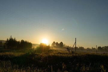 dawn on the background of a field with power lines