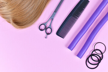 Hair styling concept with dark blond hair, elastic hair ties, comb, thinning shears, and papillote...