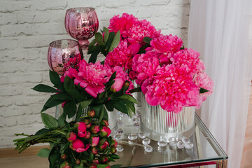 composition of peonies in silver boxes standing on a glass table