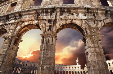 View on church bell tower through amphitheater arches with a purple sunrise sky background