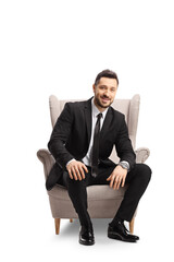 Professional man in a suit smiling and sitting in an armchair