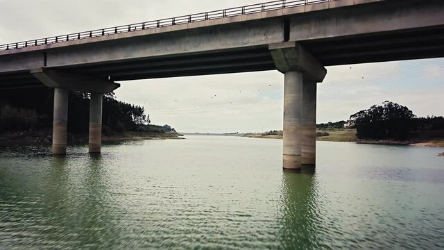 Under the bridge aerial reverse mode passage with cars over it.