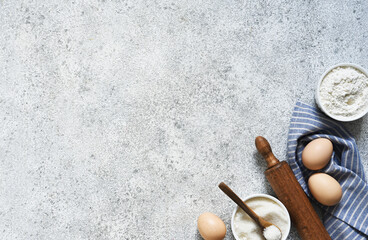 Baking background with flour, wheat ears and rolling pinon concrete background. Top view with copy space.