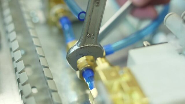 tighten brass nut with wrench in pneumatic automation system