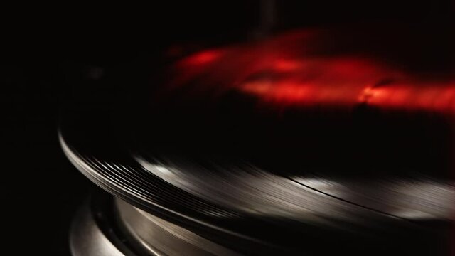 Cinemagraph loop vinyl record player turntable with its stylus running along music plate. Neon light. Retro-styled spinning record vinyl player. Close up
