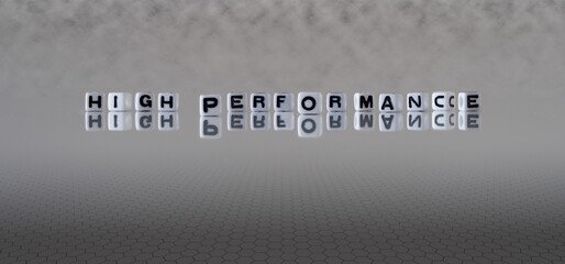 high performance concept represented by black and white letter cubes on a grey horizon background stretching to infinity