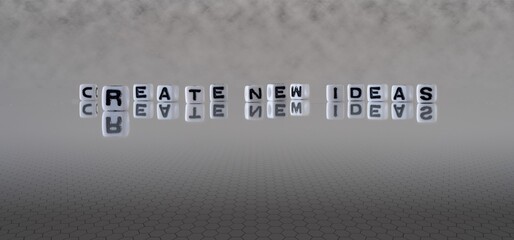 create new ideas concept represented by black and white letter cubes on a grey horizon background stretching to infinity