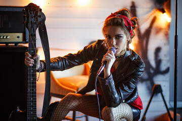 girl in a leather jacket with a guitar