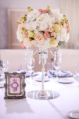 wedding spherical composition . roses, white hydrangeas on a crystal chandelier, Seating chart for guests at the event