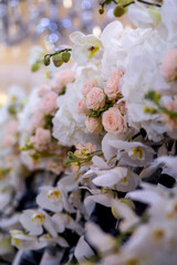 peach roses and white orchids in the wedding decor . close up. side. bouquet of roses and orchids. Wedding decor .