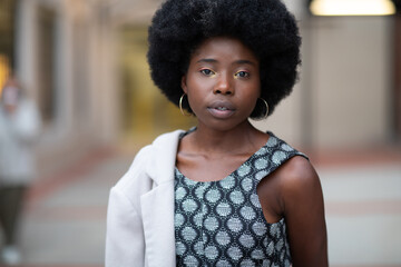 Young African American girl looking directly in the camera with a serious expression on her face, waiting for a response.