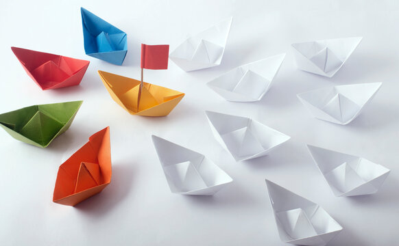 Team Work Concept using  different color Origami Paper Boats (ships)
