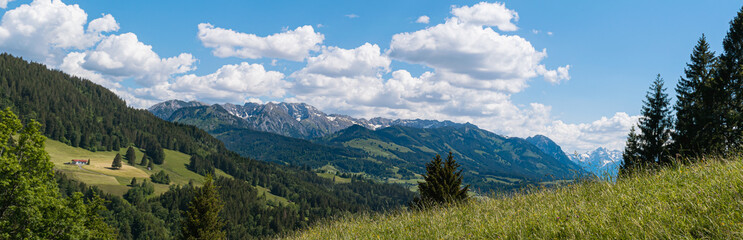 Fototapeta na wymiar Panorama of the Bavarian Alps on a sunny-cloudy day in Allgäu, Germany