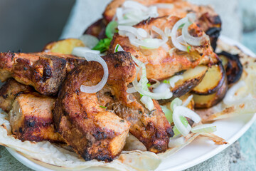 Appetizing pork grill skewers with onions on a plate