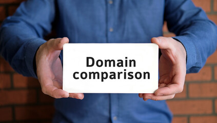 Domain comparison - seo concept in the hands of a young man in a blue shirt