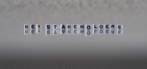 key stakeholders concept represented by black and white letter cubes on a grey horizon background stretching to infinity