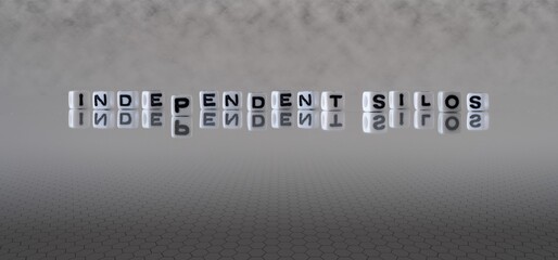 independent silos concept represented by black and white letter cubes on a grey horizon background stretching to infinity © lexiconimages