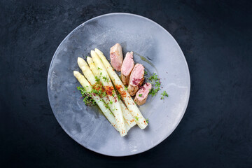 Gebratenes iberisches Schweine Fillet aufgeschnitten und angeboten mit blanchierten weißen Spargel...