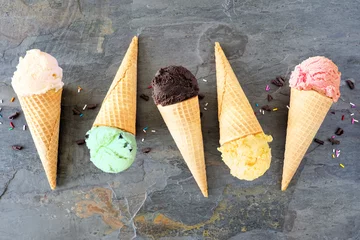  Ice cream cone flat lay over a dark slate background. Vanilla, mint, chocolate, lemon and strawberry flavors. © Jenifoto