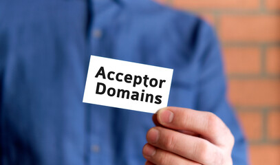 A man in a blue shirt holds a sign with the text of Acceptor Domain in one hand