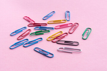 multicolor paper clips , stationery for school or business on a purple background