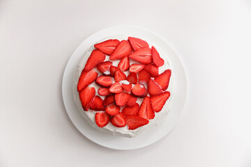 Strawberry cake with cream on a plate on a white background 