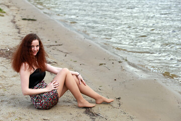 Fototapeta na wymiar A girl at the river shore in spring
