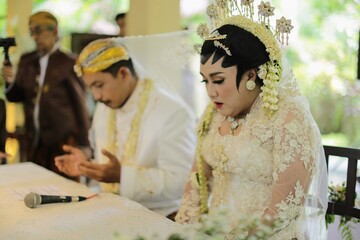 Indonesian bridal couples were undergoing the marriage ceremony event using lovely white  java wedding costume.