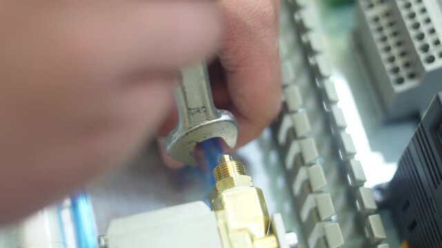 tighten brass nut with wrench in pneumatic automation system