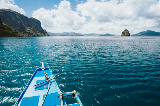 Island hopping Tour boat hover over blue ocean between exotic islands on excursion trip exploring Bacuit archipelago, El Nido, Philippines