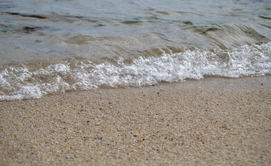 Pequenas ondas a enrolar na areia da praia