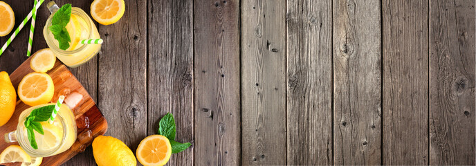 Cold summer lemonade banner with corner border. Top view on a dark wood background with copy space.