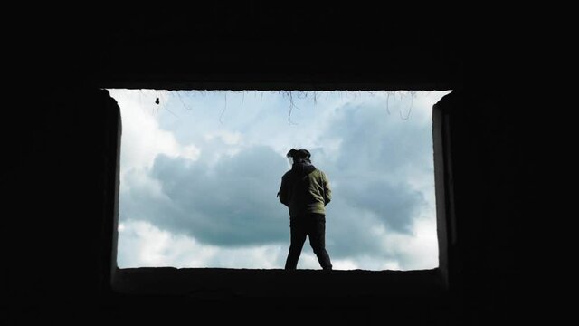 A guy waves a bat against the sky in an abandoned house. Riots in the city. Dangerous people