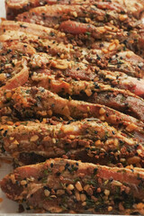 Fresh pork belly slices in Korean style marinate and herbs on a plastic tray on simple table cloth.